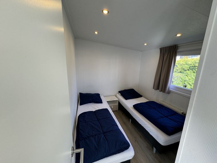 Slaapkamer met twee eenpersoonsbedden en nachtkastje