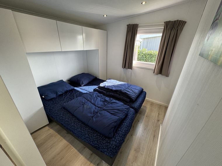 Slaapkamer met tweepersoonsbed en opbergkasten