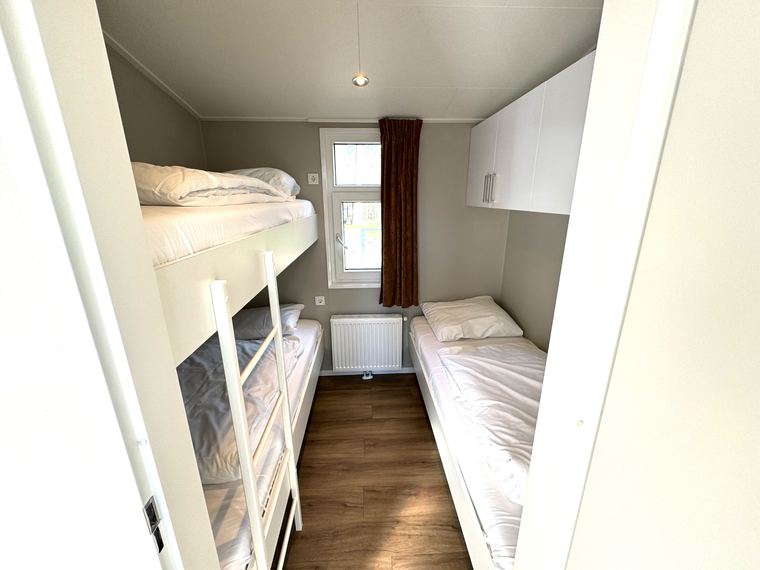Slaapkamer met stapelbed en een eenpersoonsbed