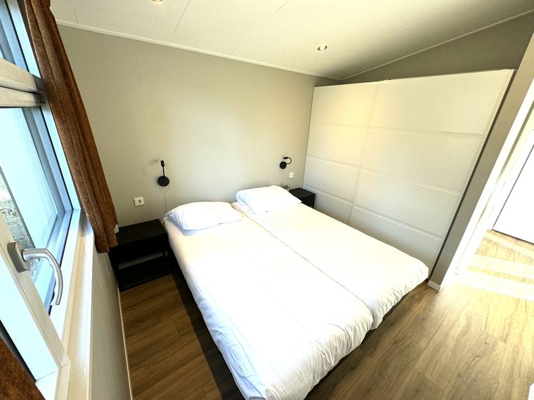 Slaapkamer met tweepersoonsbed en schuifdeurkast