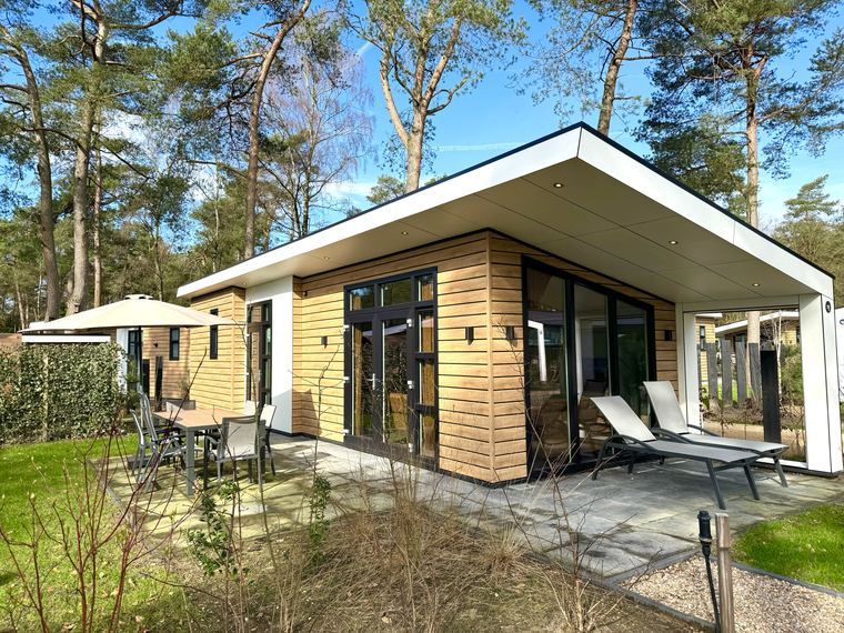 Voorzijde van boslodge 151 met schuifpui en overdekt terras