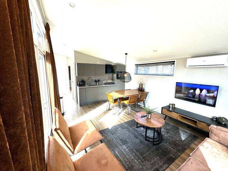 Woonkamer met zicht op de open keuken en airconditioning